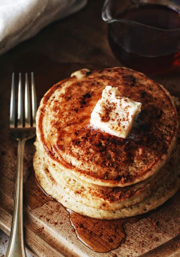 overhead shot of pancakes with cinnamon and butter and syrup