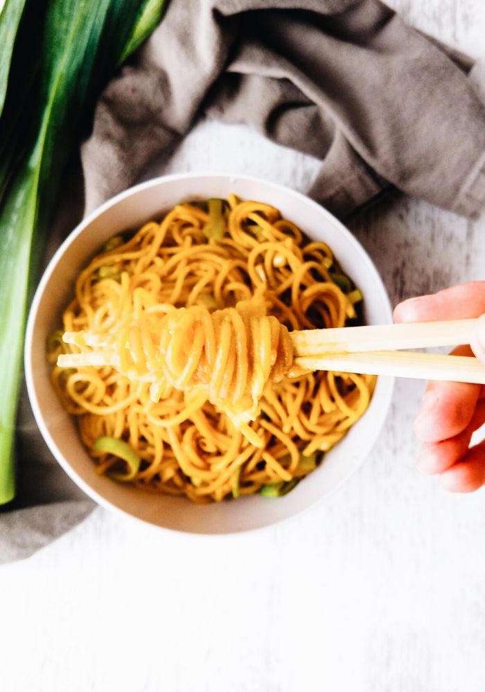 hand lifting up stir fried noodles