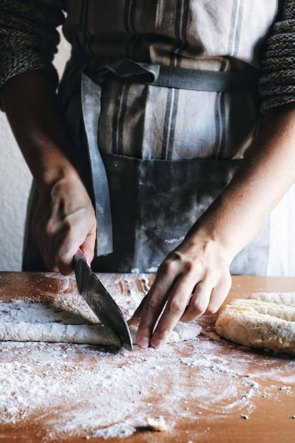 hands cutting gnocchi dough into pieces