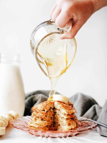 Pouring honey over delicious banana oatmeal pancakes