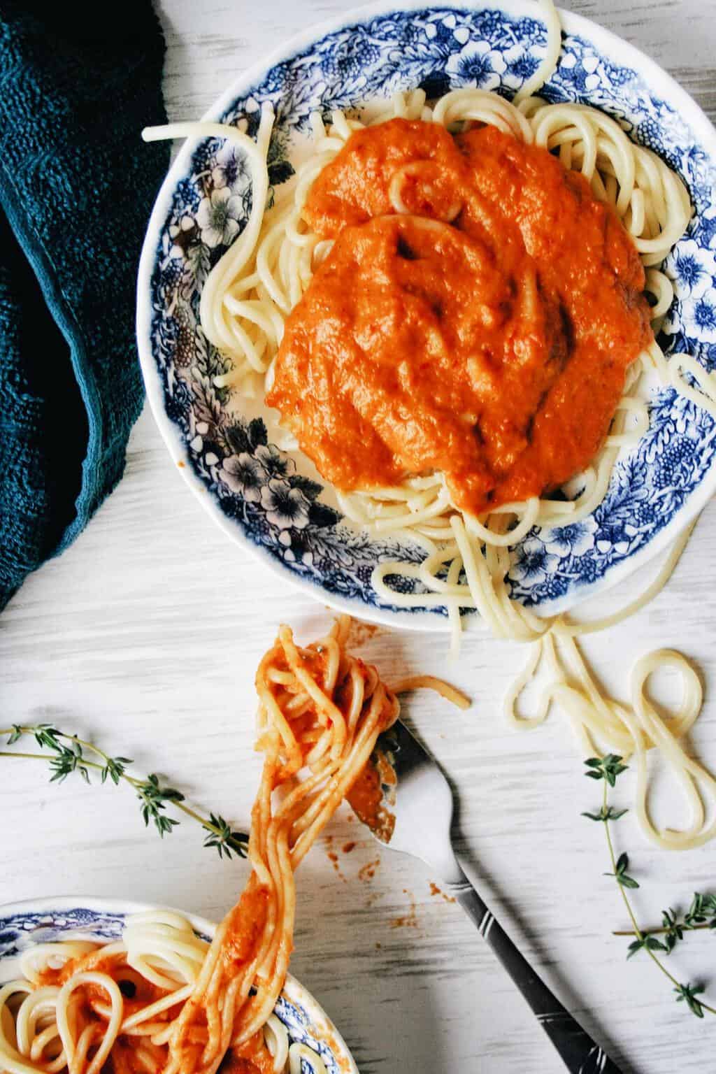 close up picture of vegan roasted red pepper sauce on a bowl of spaghetti