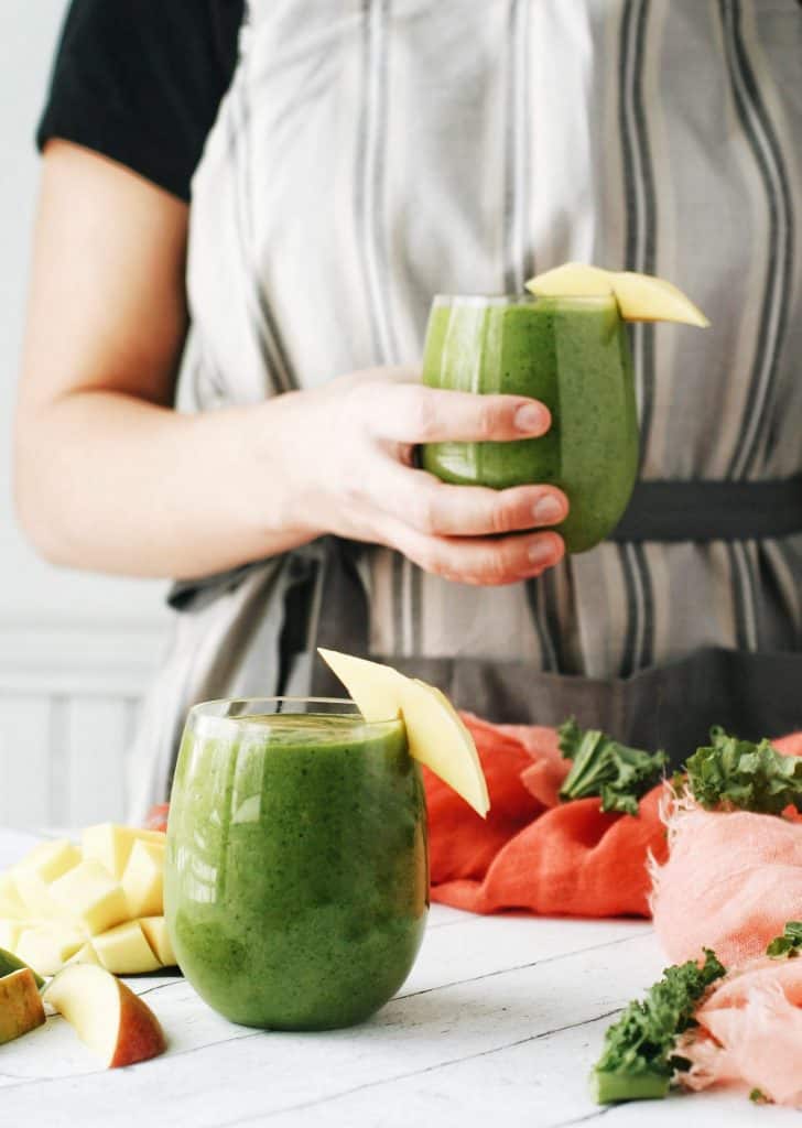 hand holding a green smoothie