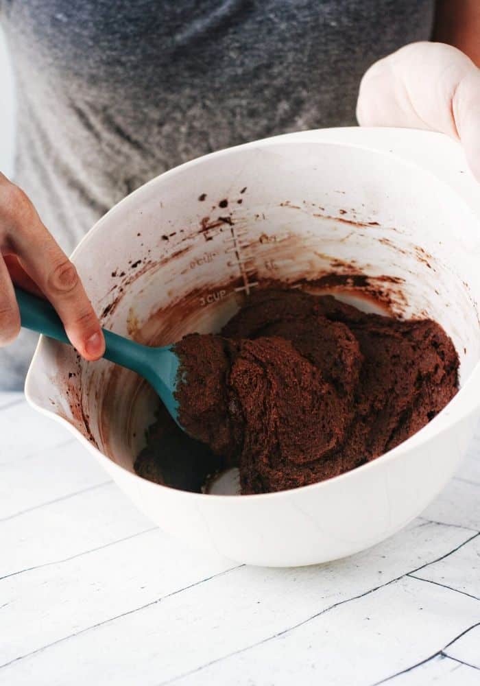 hand mixing up some brownie batter