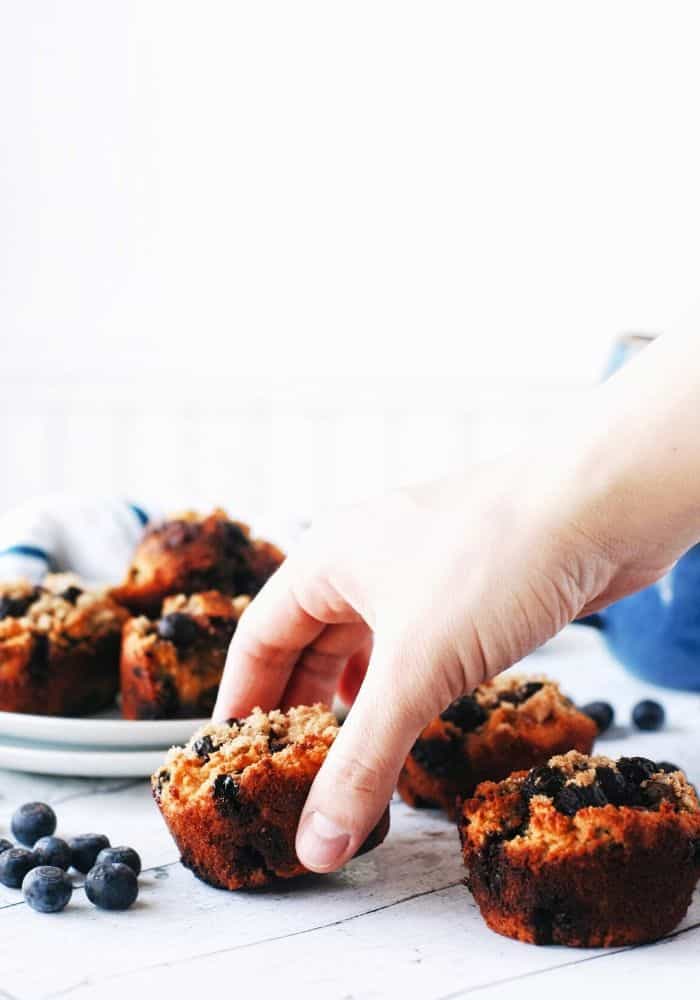 hand reaching for a blueberry sweet potato muffin