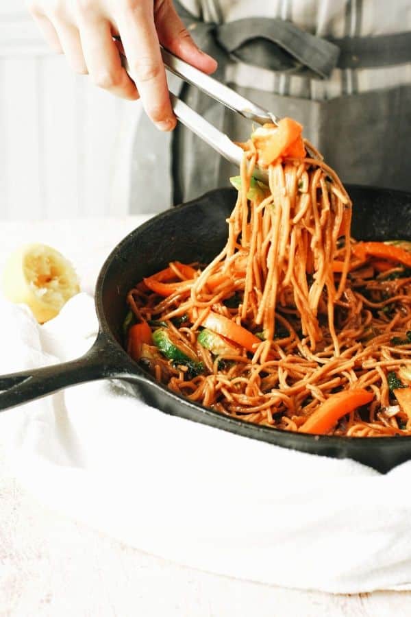 scooping up fried noodles and veggies