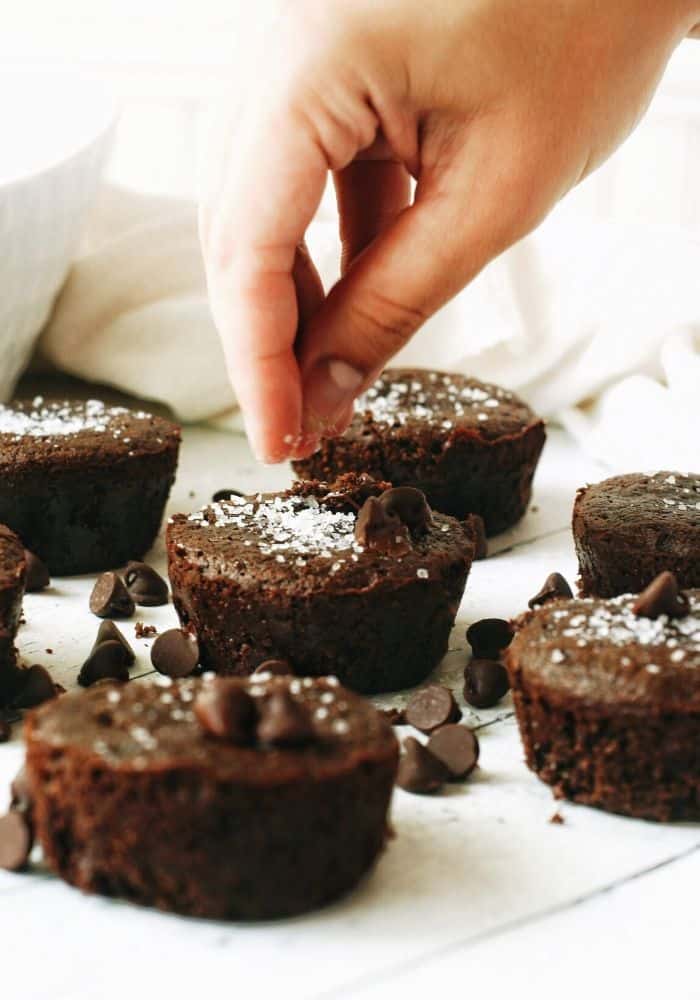 hand sprinkling sea salt onto a chocolate muffin