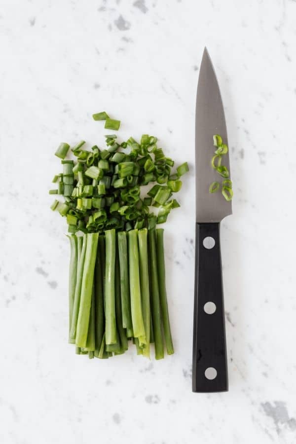 knife chopping up fresh herbs