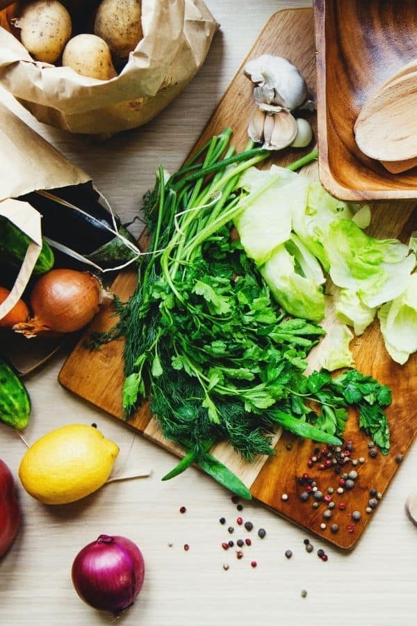 cutting board with herbs and fresh veggies