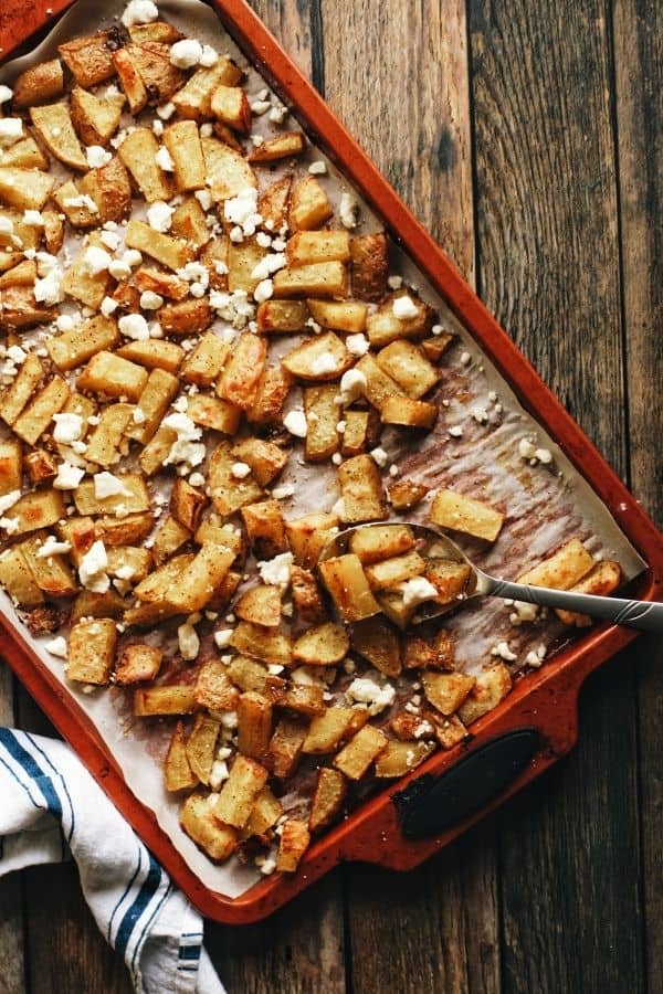 full overhead shot of a pan full of oven roasted garlicky potatoes and feta