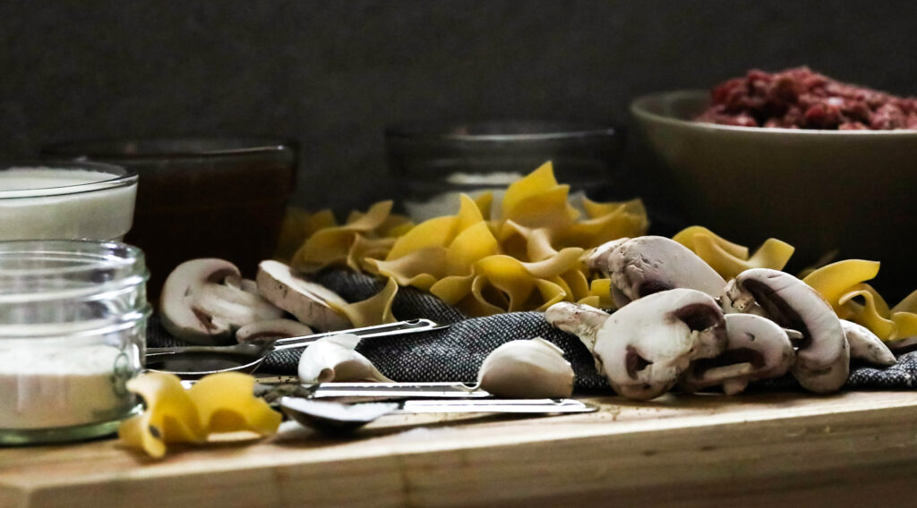 ingredients for beef stroganoff on a cutting board