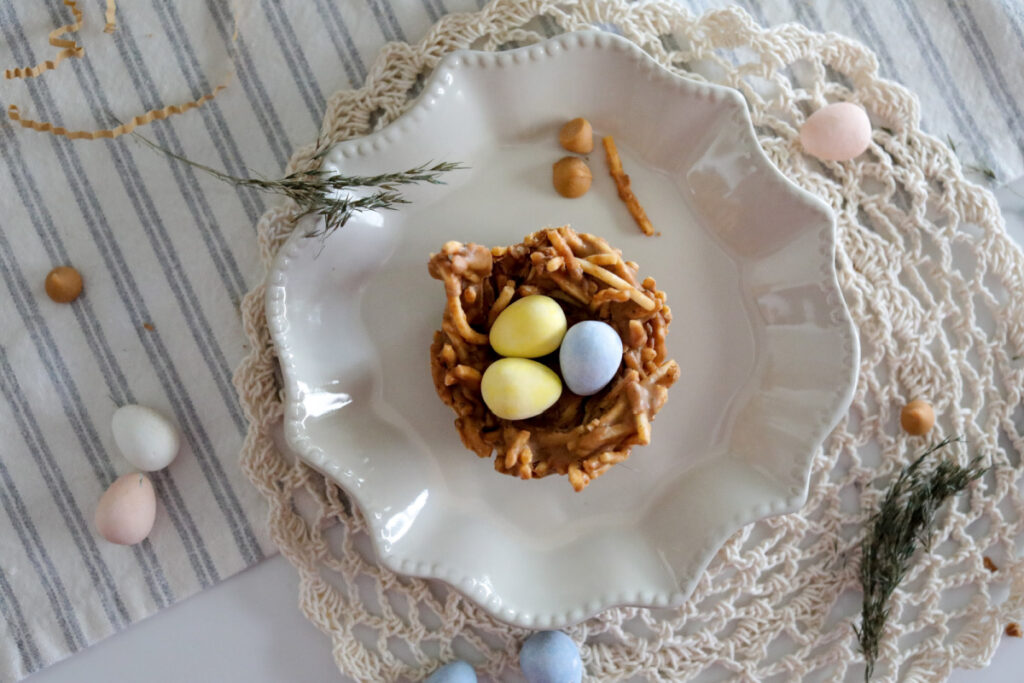 above horizonal photo of easter bird nest cookies on a plate with candy eggs in the center