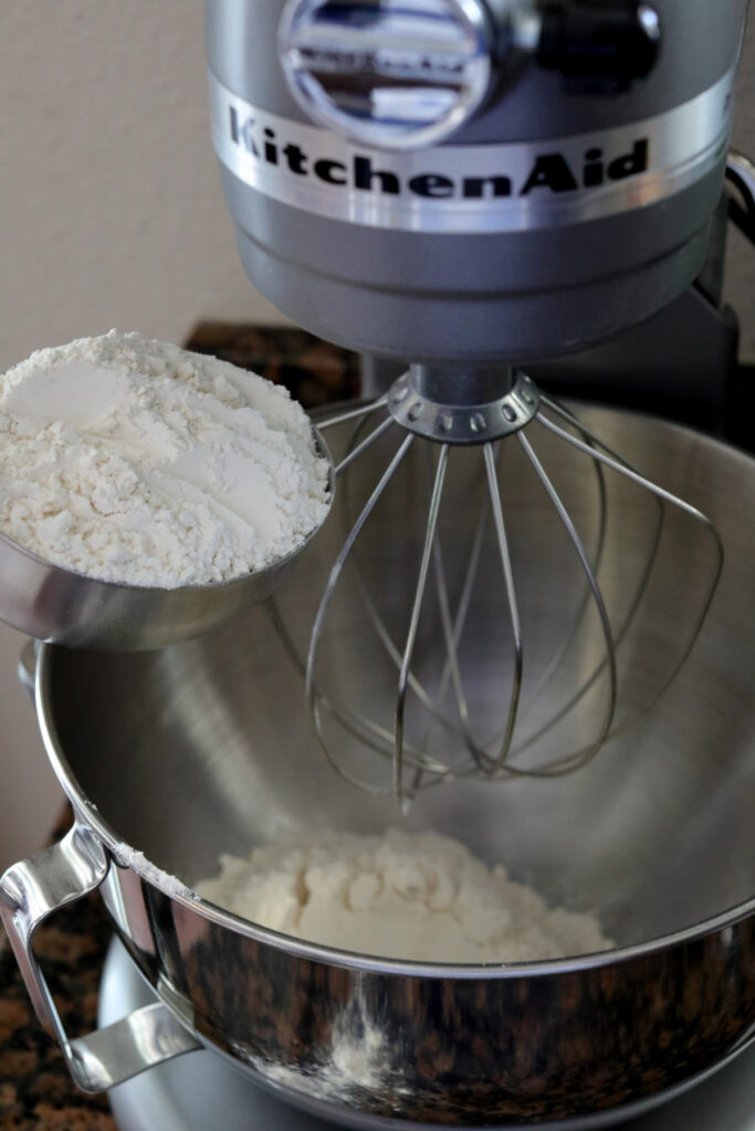 adding flour to mixing bowl