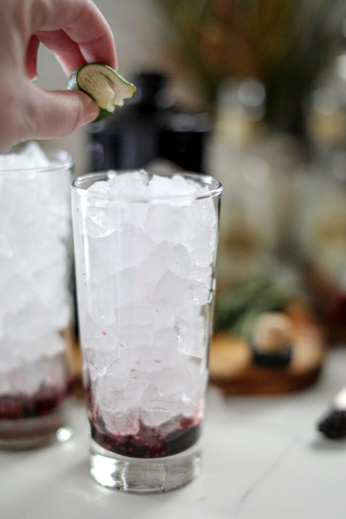 ice in the class with muddled blackberries and squeezing in a lime
