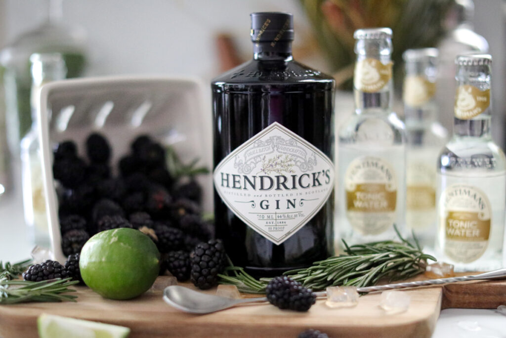 close up photo of hendricks gin with blackberries around with a spoon in front of it